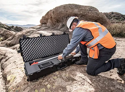 Mann plukker utstyr ut av kasse